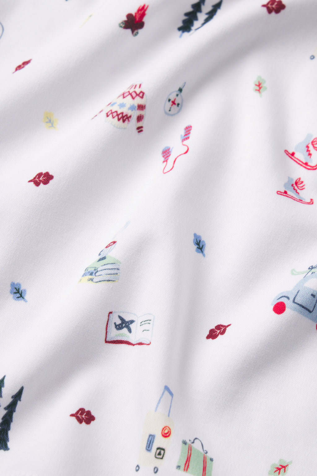The Kids Long-Long Set in Alpine Adventure features white Pima cotton fabric adorned with vibrant illustrations of trees, leaves, suitcases, snowflakes, and travel themes for a playful look.