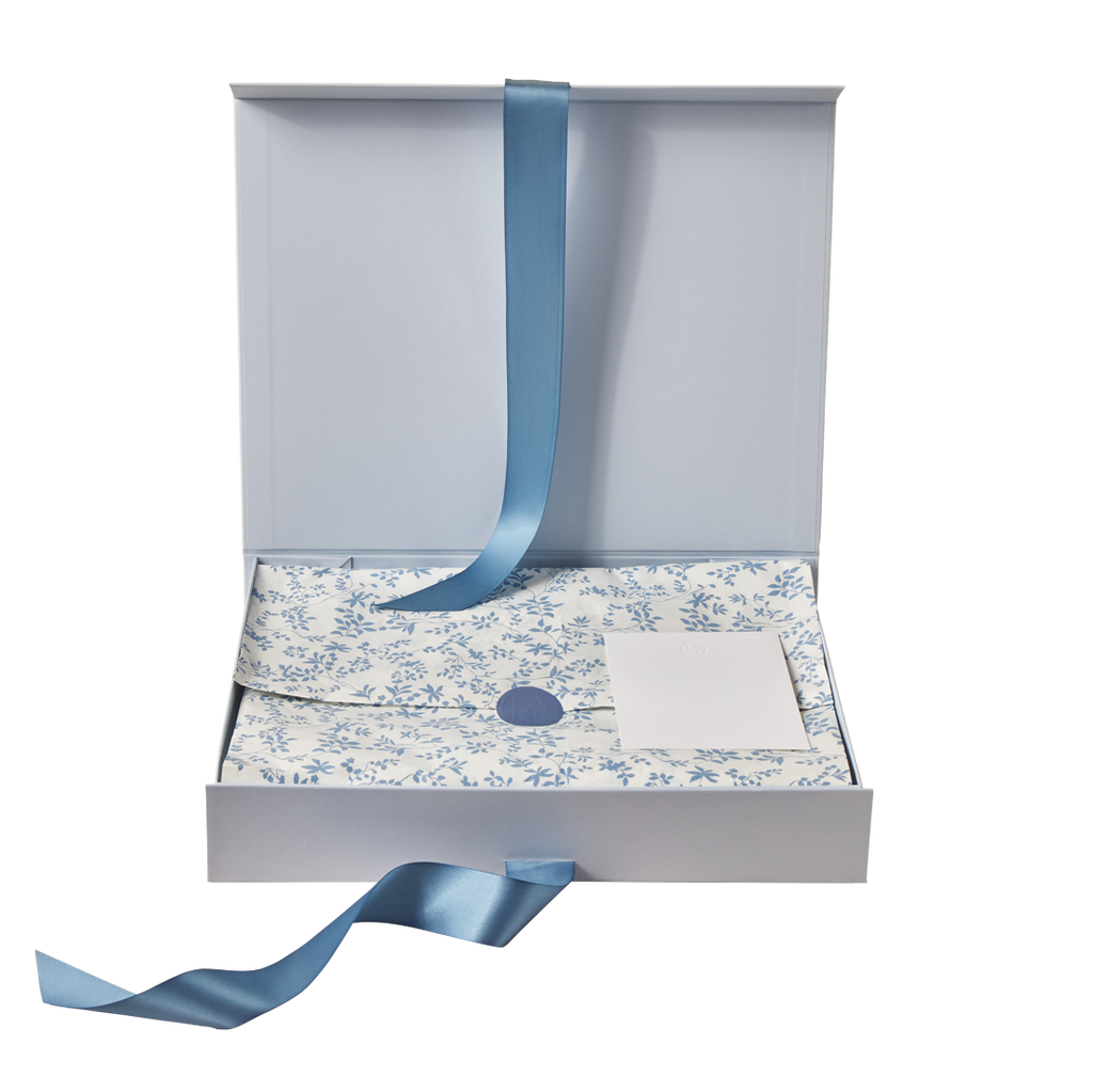 Gray assembled box with blue ribbon closure, floral patterned interior, and white card insert.