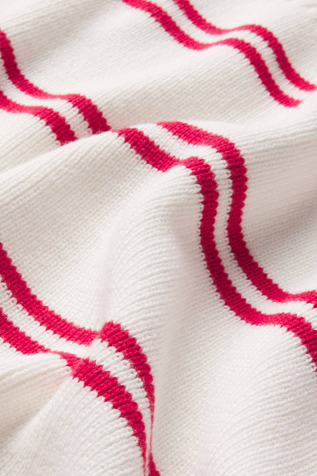 Close-up of the Nora Cotton Cardigan in Ivory Red Stripe, showcasing its soft, knitted texture with evenly spaced horizontal ivory and red stripes for a classic varsity look.