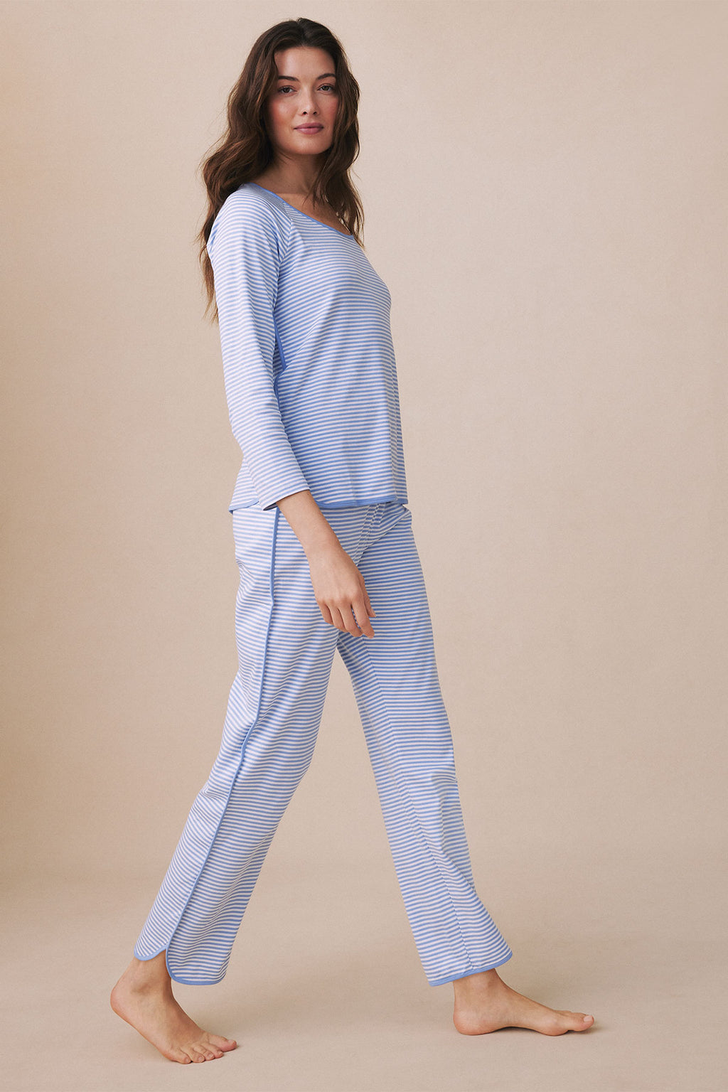 Woman wearing blue and white striped long-sleeve top and matching pants, shown in side profile.