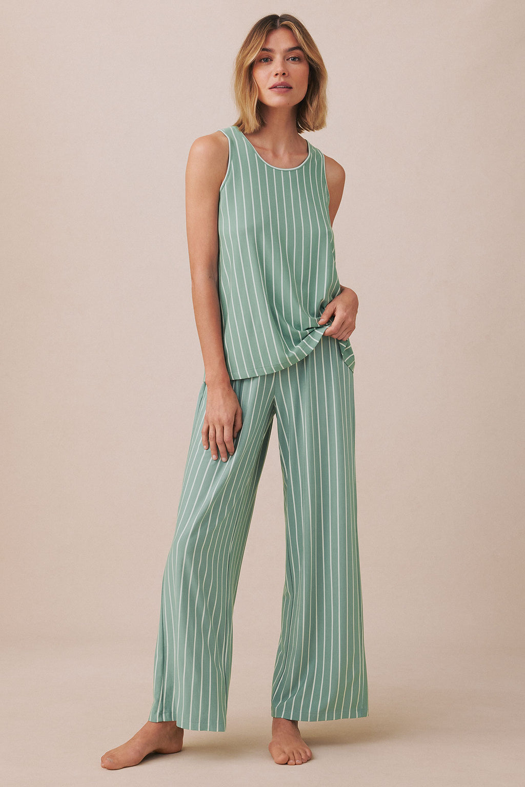 Woman wearing boxwood green vertical-striped sleeveless tank top and matching wide-leg pants.
