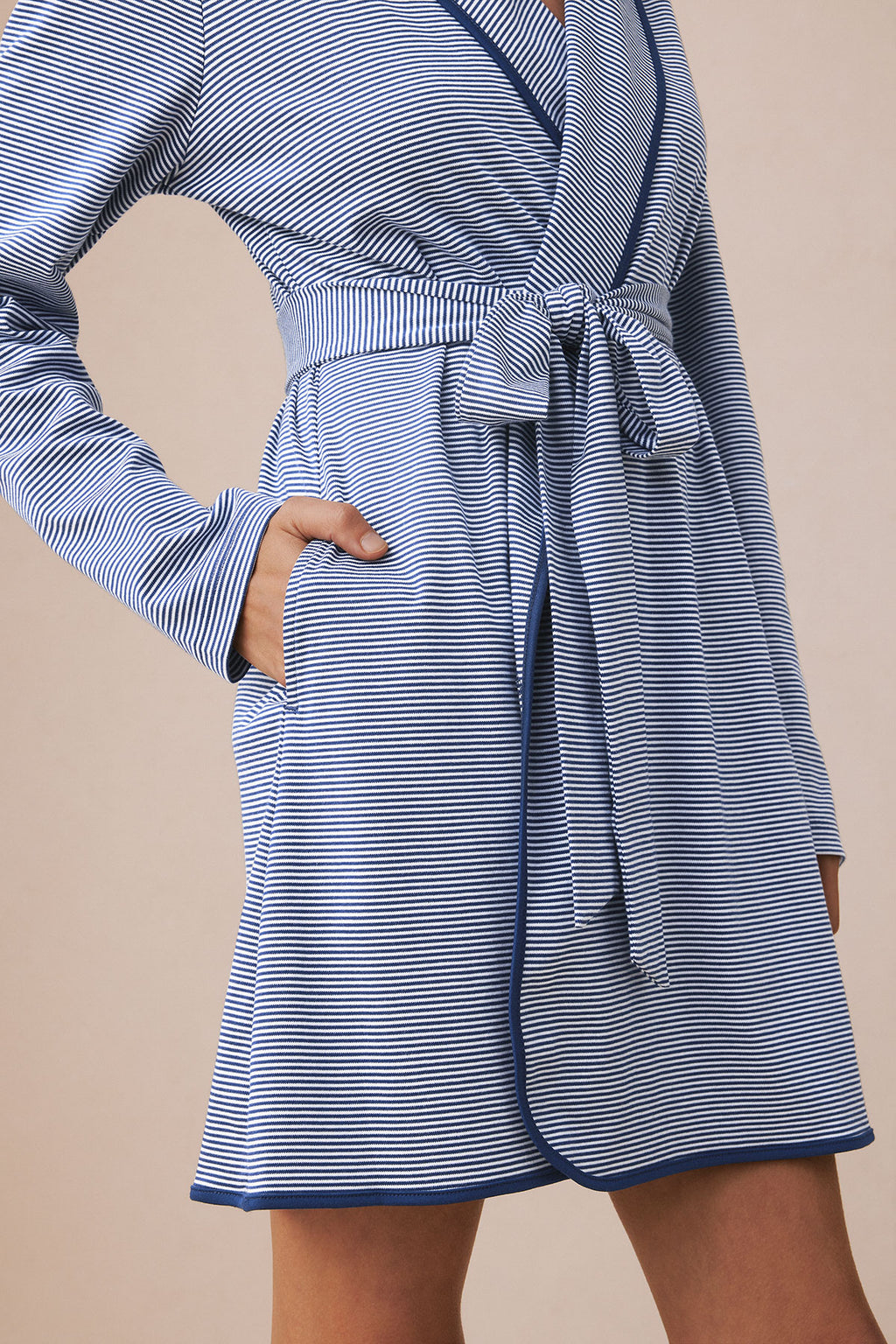 Blue and white striped short robe with long sleeves, front tie closure, and patch pockets.