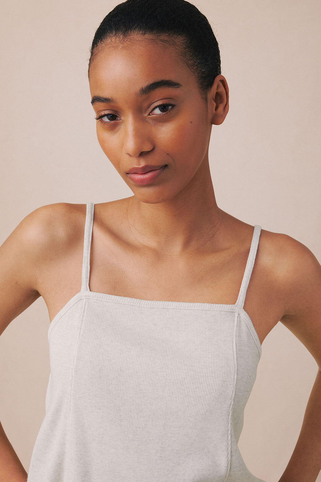 Stone heather ribbed tank top with thin shoulder straps on model against neutral background.