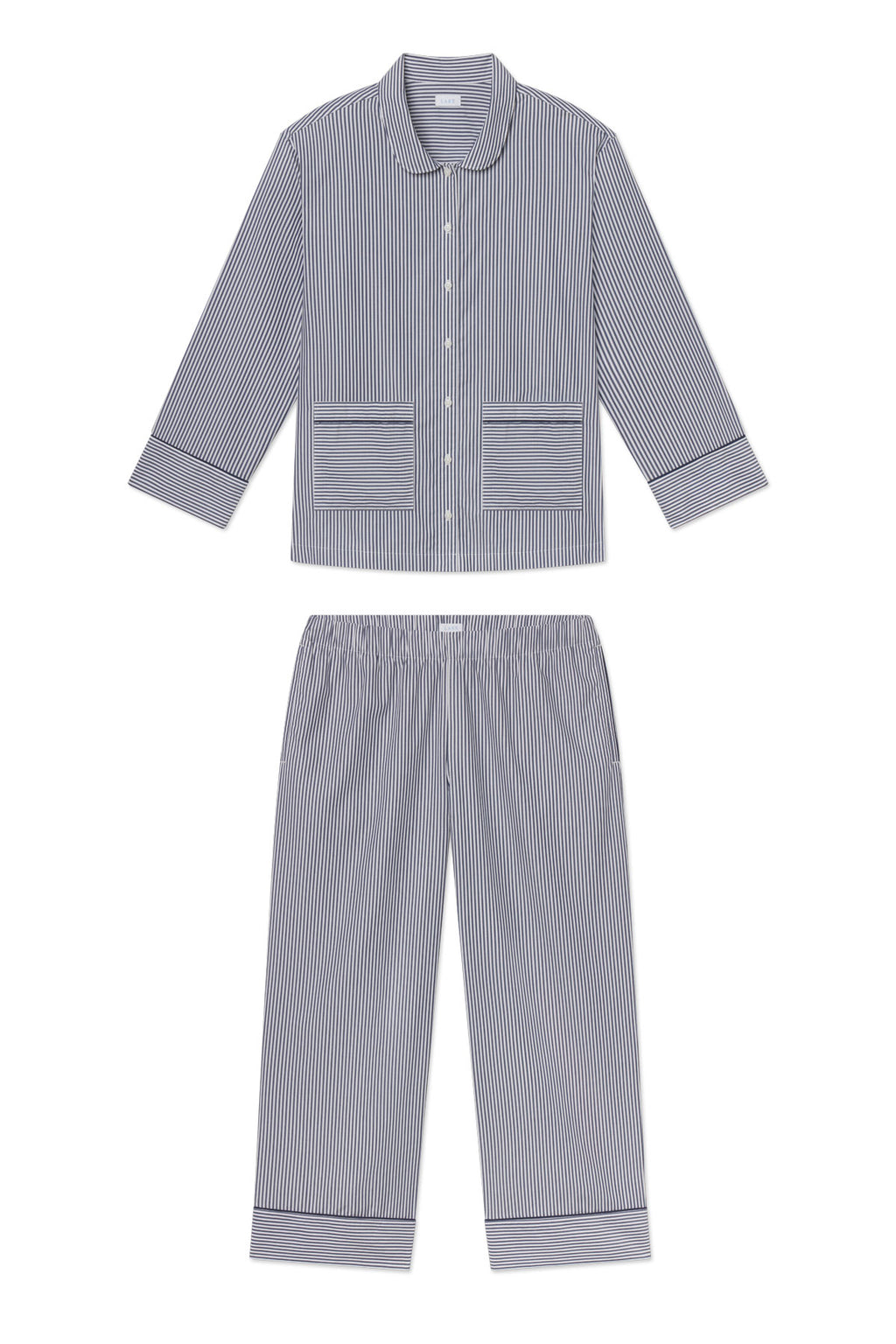The Poplin Piped Long-Long Set in English Navy Riviera Stripe features blue and white vertical stripes, a button-up long-sleeve top with two front pockets, and matching elastic-waist pants, both with solid blue cuffs for classic cotton comfort.