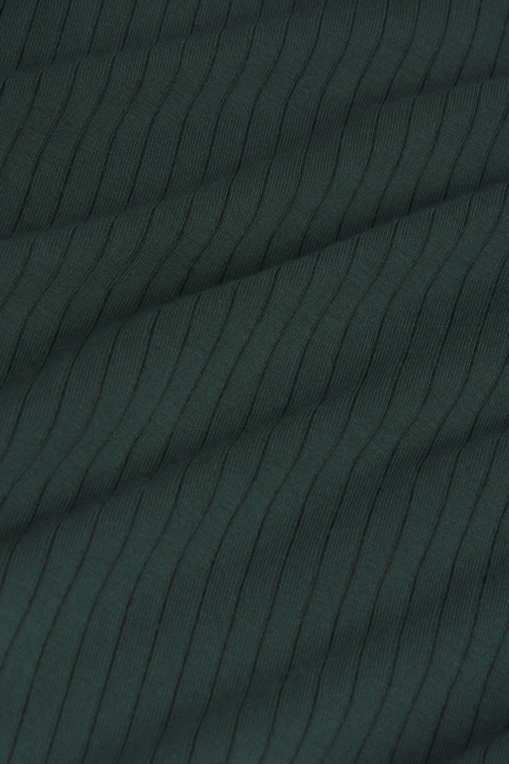 Close-up of conifer green ribbed fabric with vertical texture and diagonal folds.