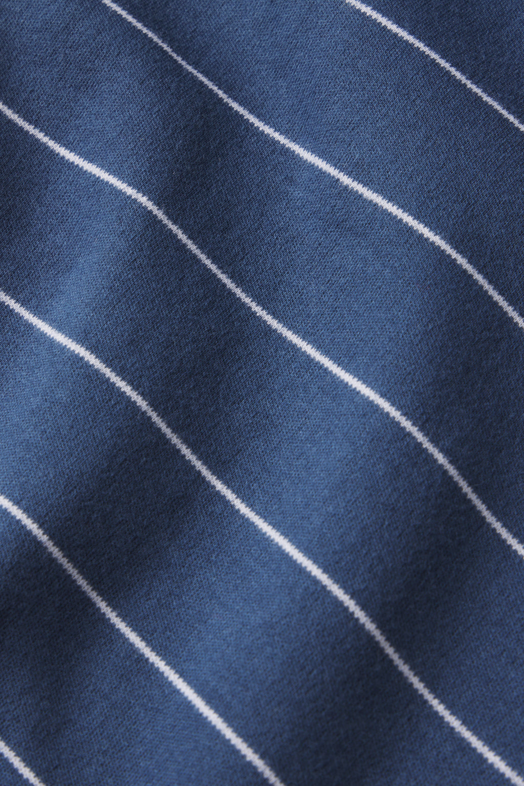 Close-up of the Pima Shorts Set in Navy Boating Stripe, featuring soft blue fabric with thin white diagonal stripes and a slightly wrinkled texture—perfect for comfortable women’s loungewear.