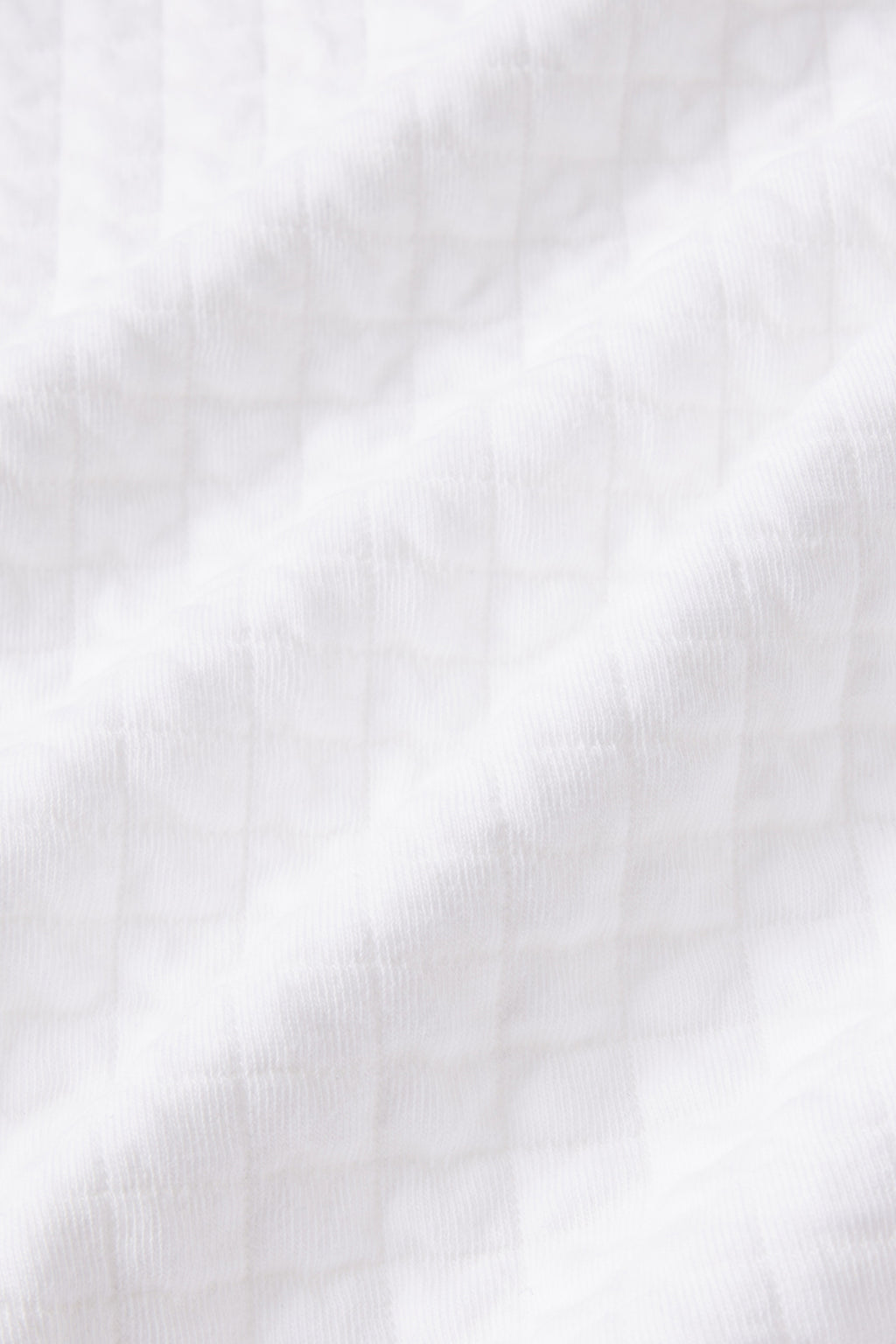 Close-up of the Jacquard Spa Robe in White, highlighting its lightweight jacquard fabric with a subtle grid texture, soft folds, and gentle shadows—perfect for spa use.