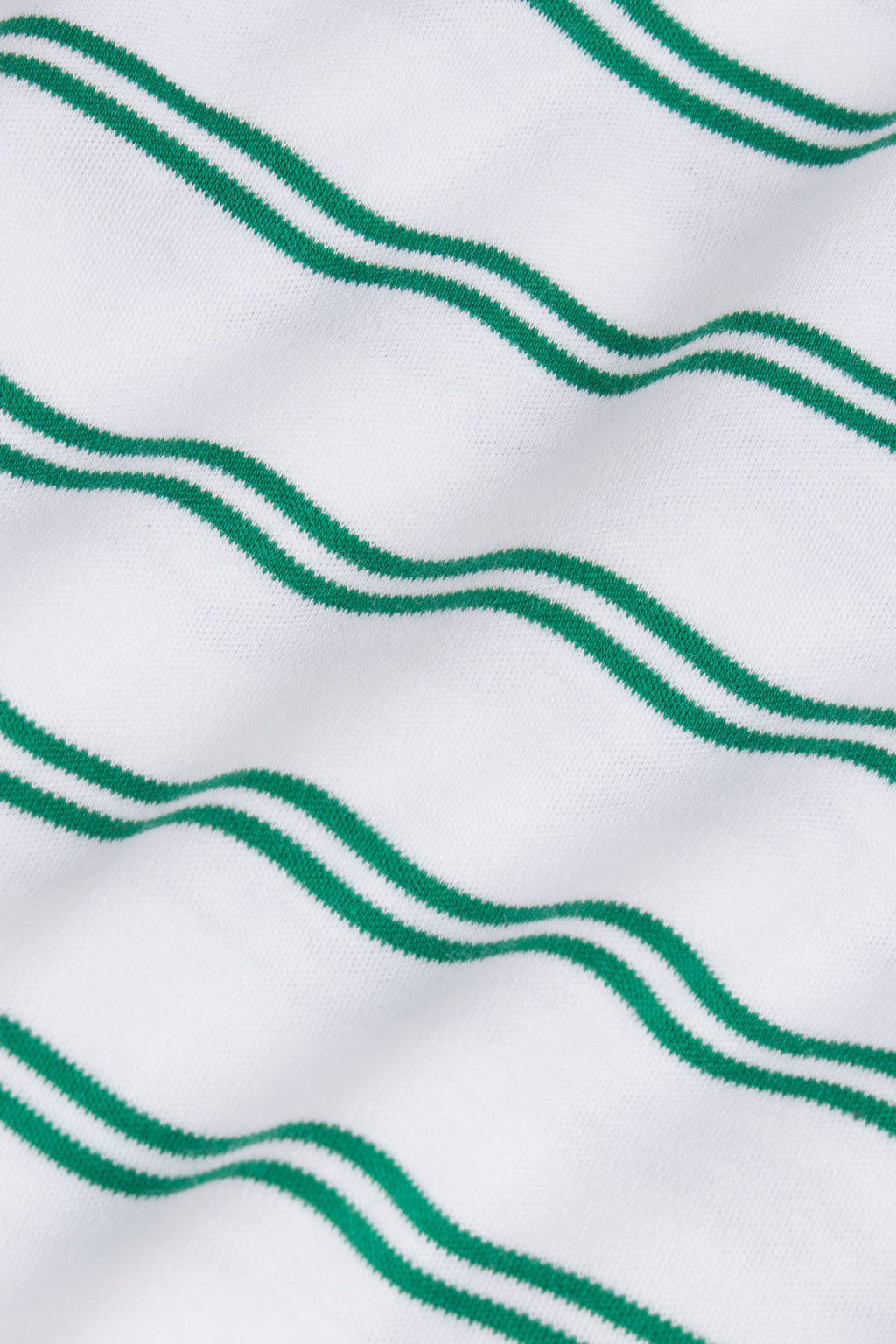 White knit fabric with green wavy horizontal stripes.
