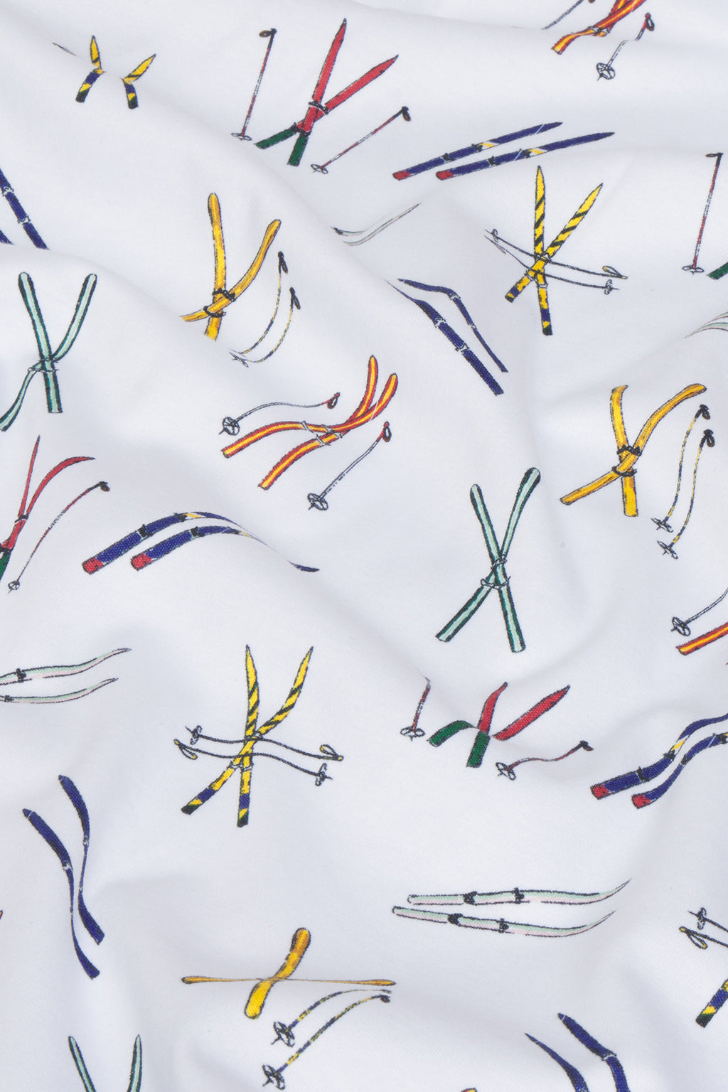 The Pima Crew Long-Long Set in Vintage Skis features white Pima cotton with colorful, hand-drawn vintage skis and ski poles in yellow, green, red, and blue accents; fabric shows gentle wrinkles and folds.