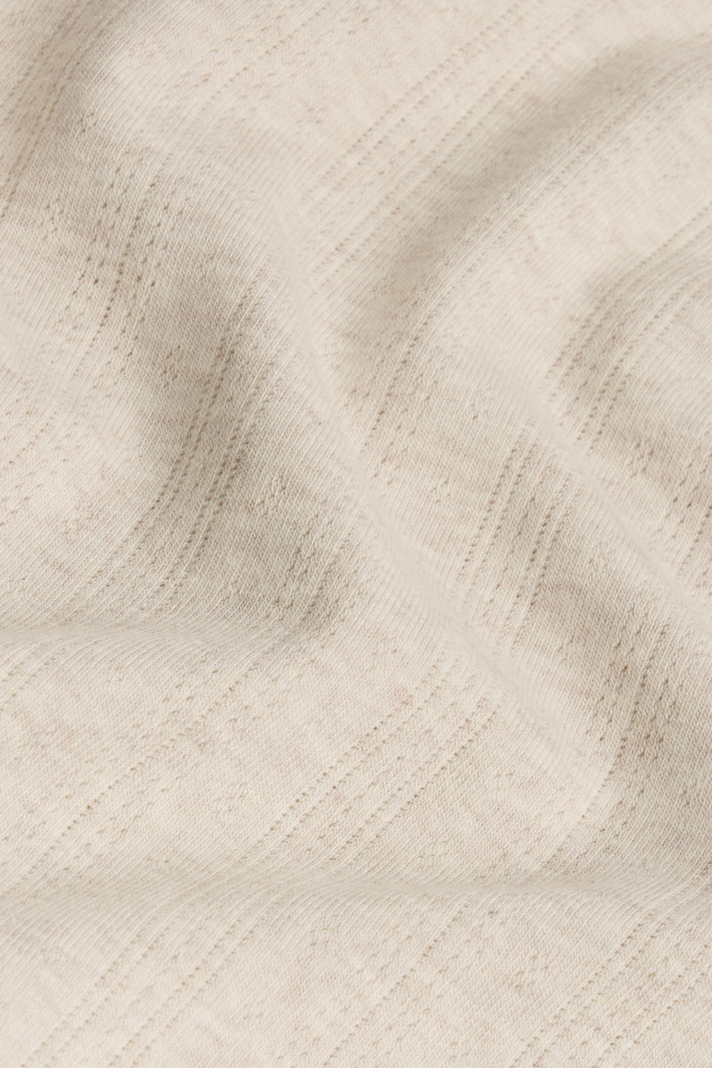 Oat heather pointelle knit fabric with vertical ribbed texture and openwork pattern detail.
