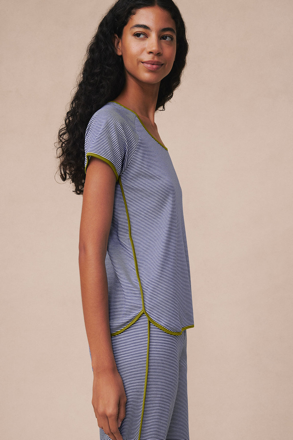 Woman wearing navy and white striped short-sleeve top with matching cropped pants and yellow trim piping.
