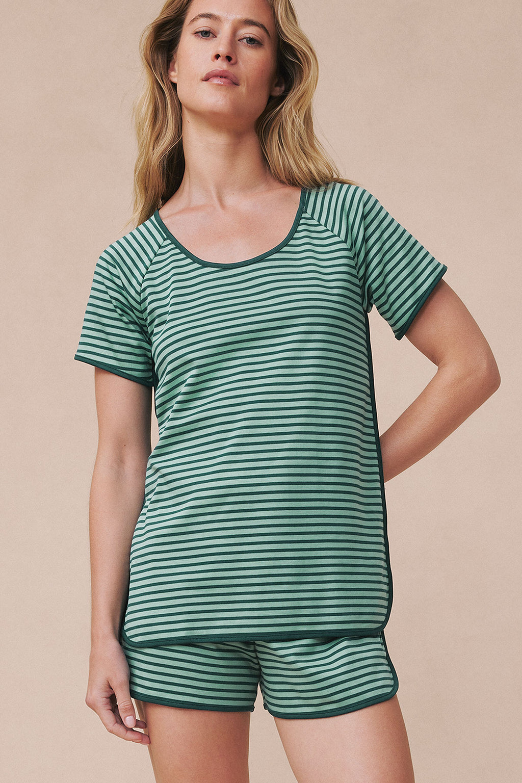 Woman wearing dark sea and light green striped short-sleeve shirt and matching shorts set.