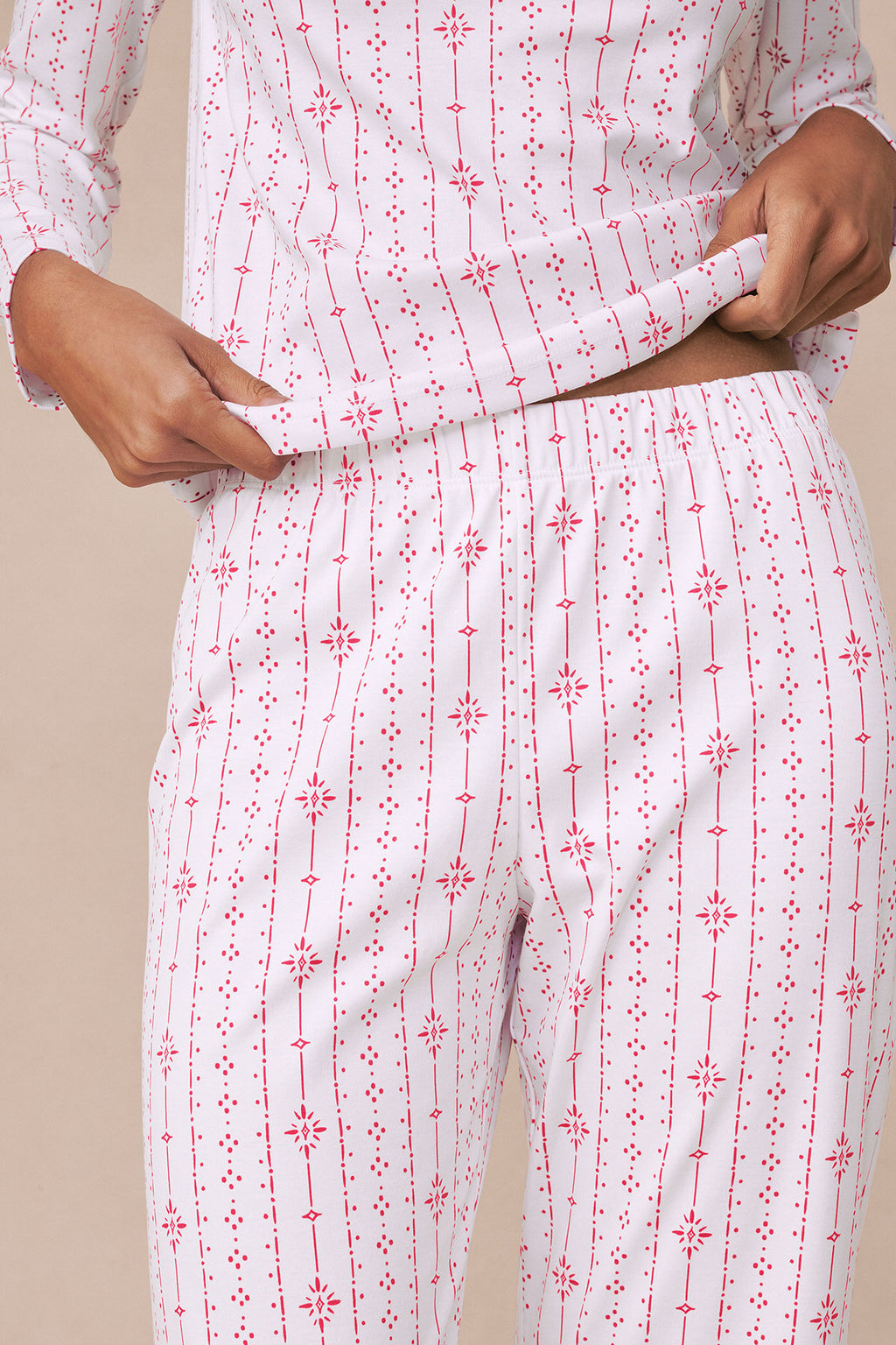 White and red striped pajama set with geometric and star pattern, long sleeves and full-length pants.