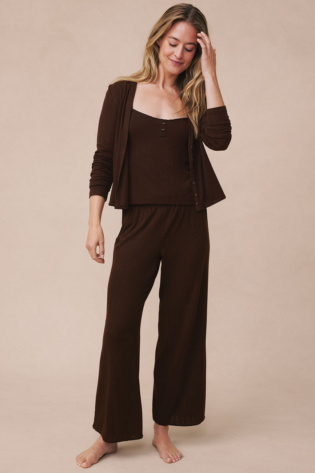 Woman wearing cocoa brown pointelle cardigan, henley top, and wide-leg pants in matching color.