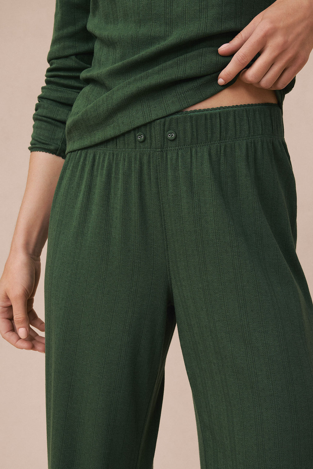 Rosemary green pointelle knit set with long-sleeve top and high-waisted pants with button detail.