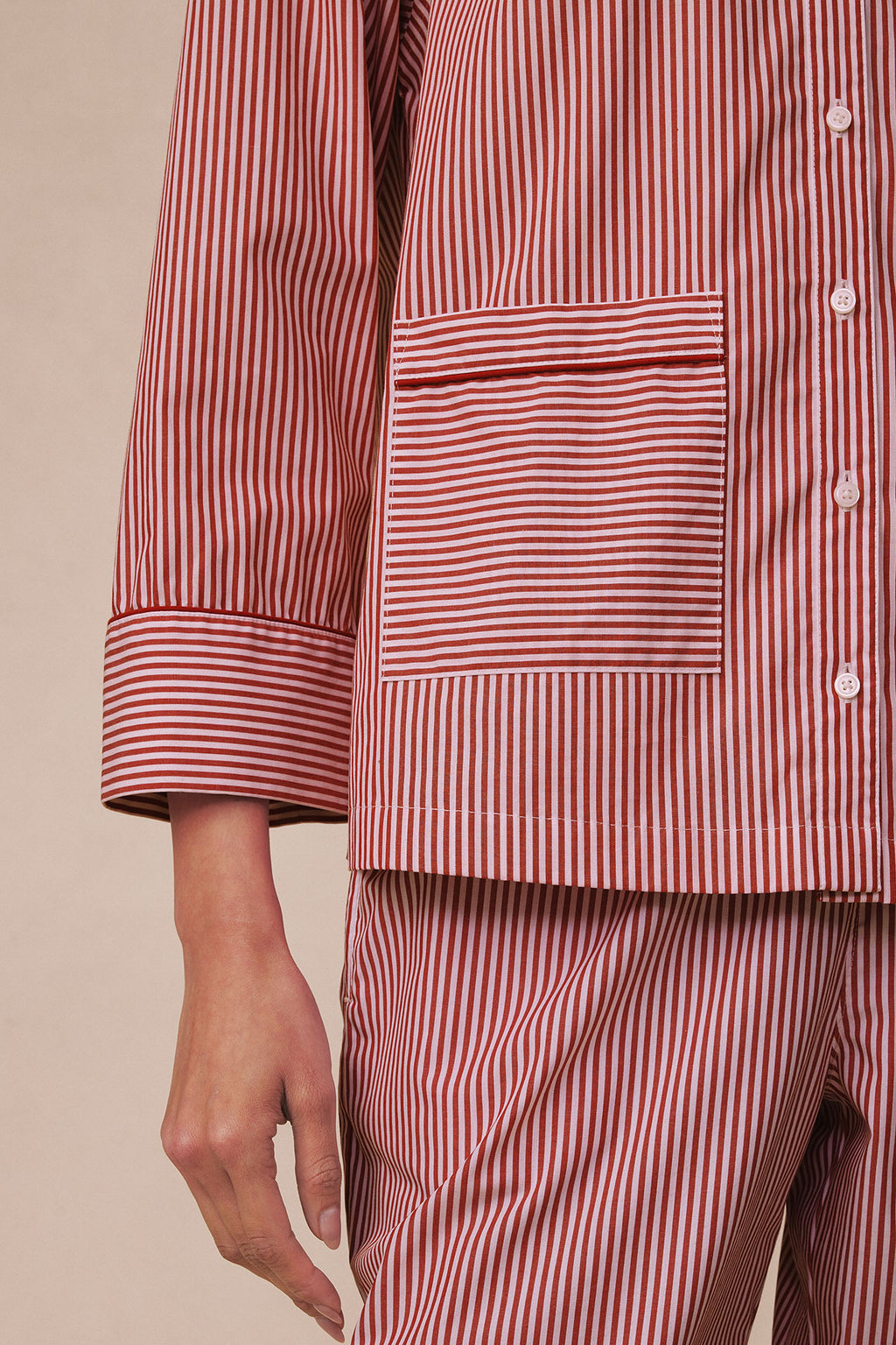 Long pajama set in red and white vertical stripes with piped trim and button front closure.