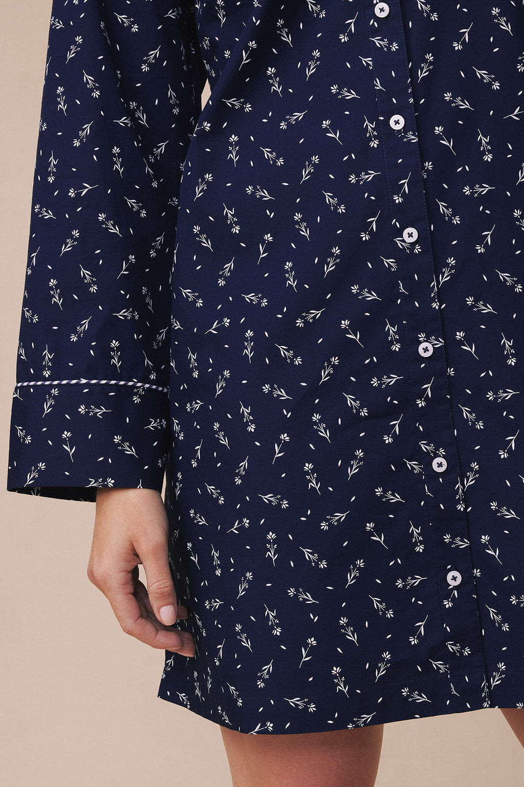 Navy nightgown with white floral print, white button closures, and piped trim at cuffs and hem.