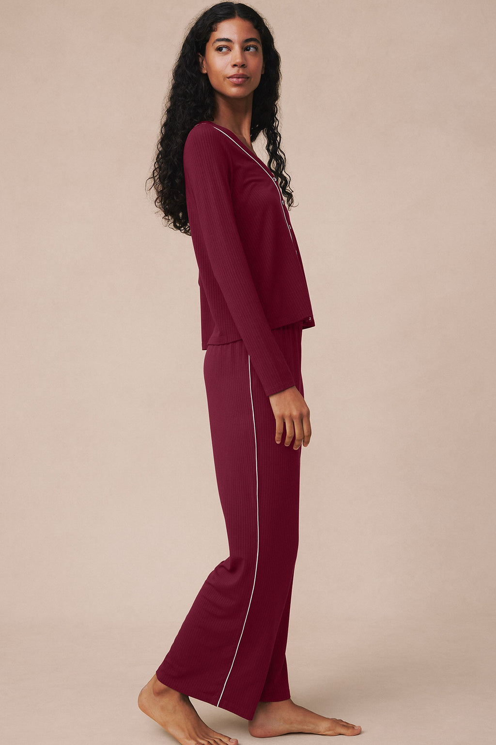 Woman wearing burgundy ribbed long-sleeve top and matching long pants with side stripe detail.
