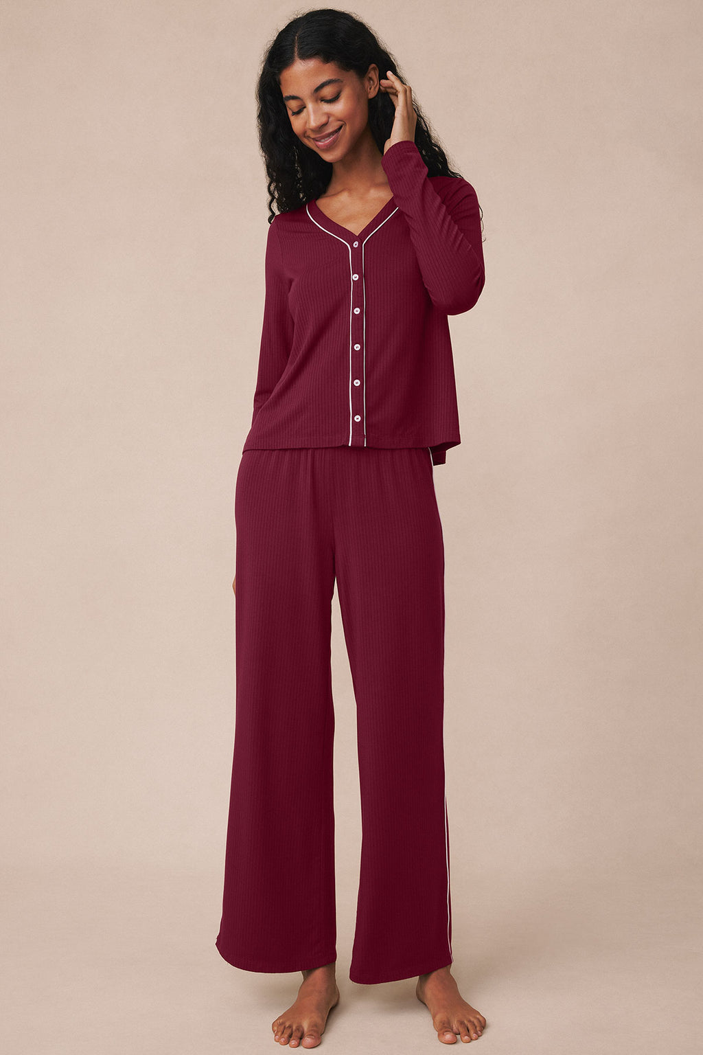 Burgundy ribbed pajama set with button-front top and long pants, shown on model.