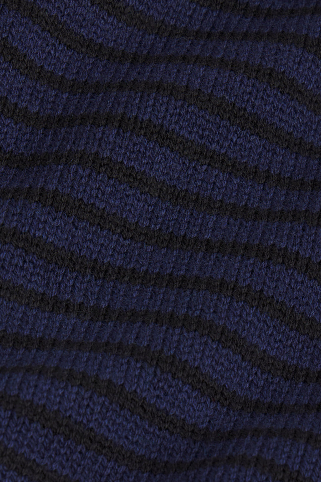 Navy and black diagonal striped knit fabric with textured surface.