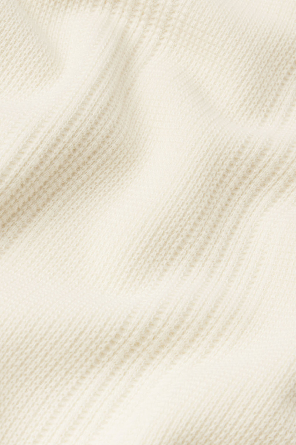 Ivory waffle-textured fabric with vertical ribbed pattern detail.