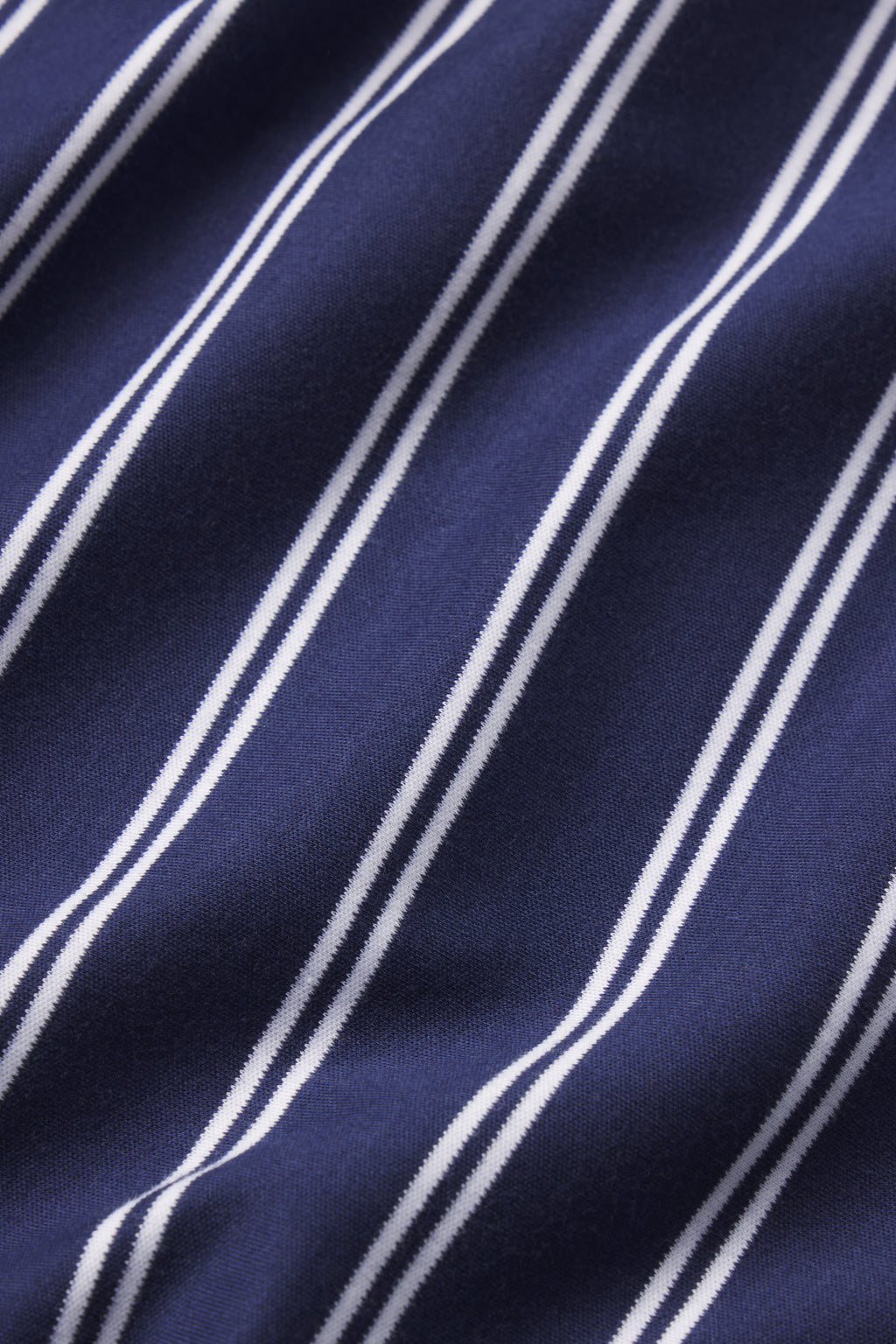 Close-up of the Pima Crew Long Sleeve Bundle in English Navy Tidal Stripe, featuring dark blue Pima cotton fabric with diagonal white stripes, highlighting its smooth texture and soft drape.