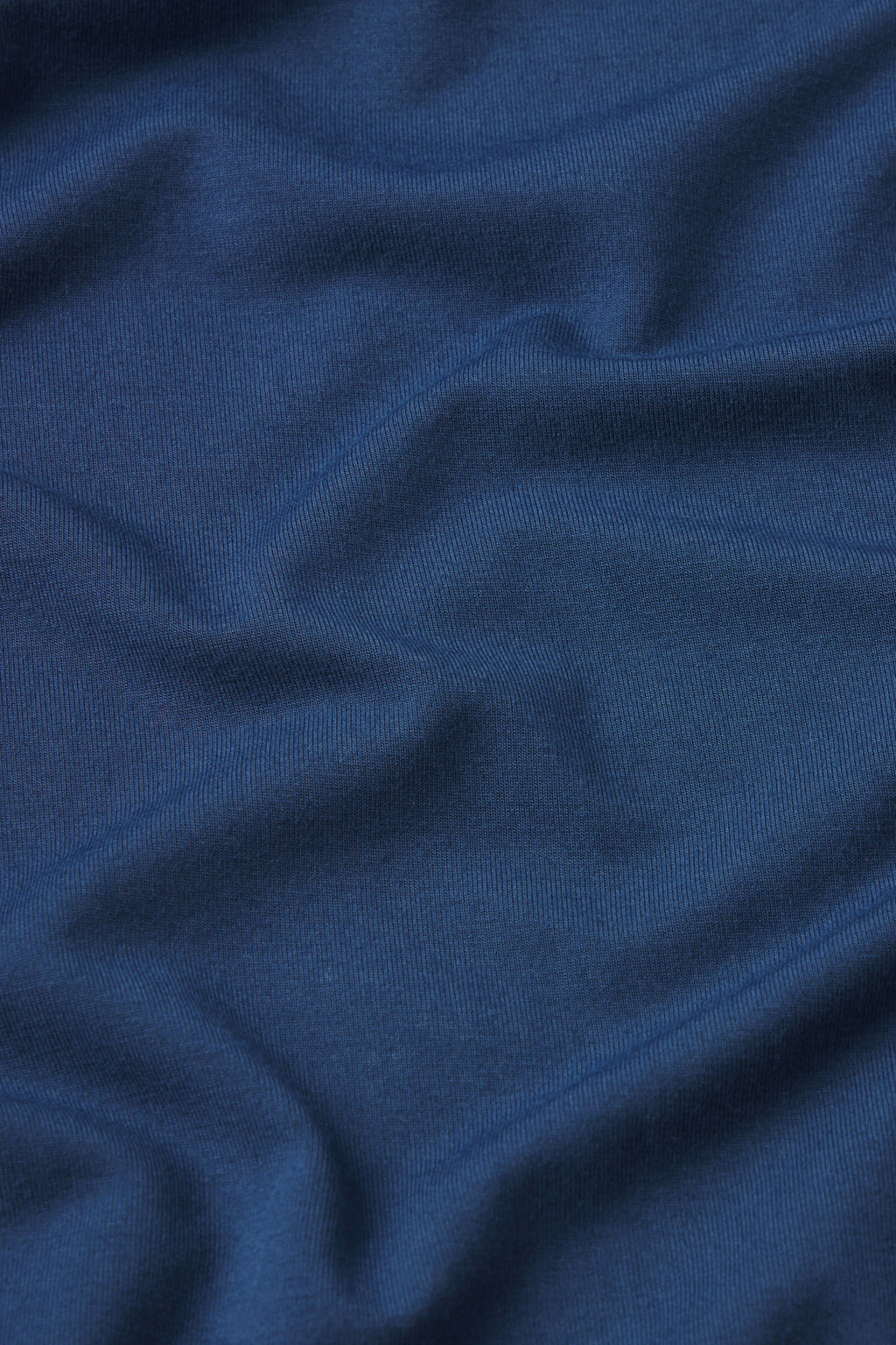 A close-up of Sea Depth Blue fabric showcases visible texture and soft folds, ideal for the Men