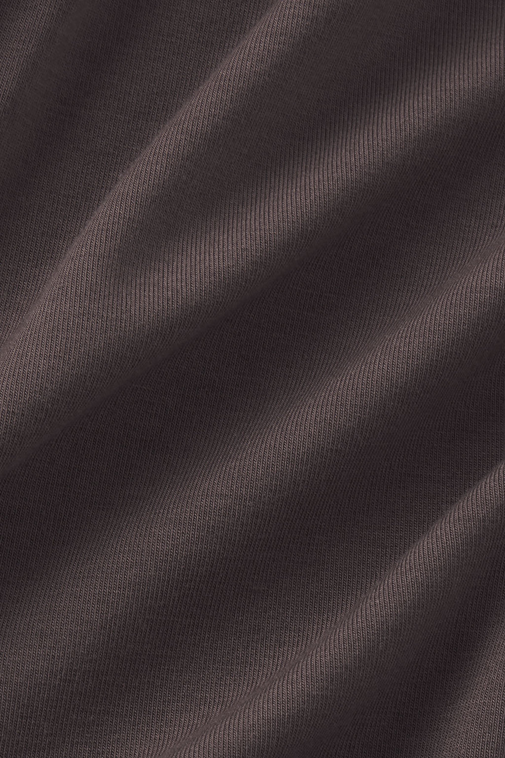 Close-up of truffle-colored ribbed knit fabric with soft draping and vertical texture detail.