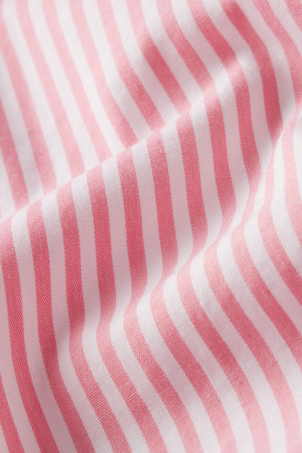 Close-up of the Poplin Piped Nightgown in Gelato Riviera Stripe, featuring soft-textured pink and white diagonal stripes and gentle folds that create shadows and depth.