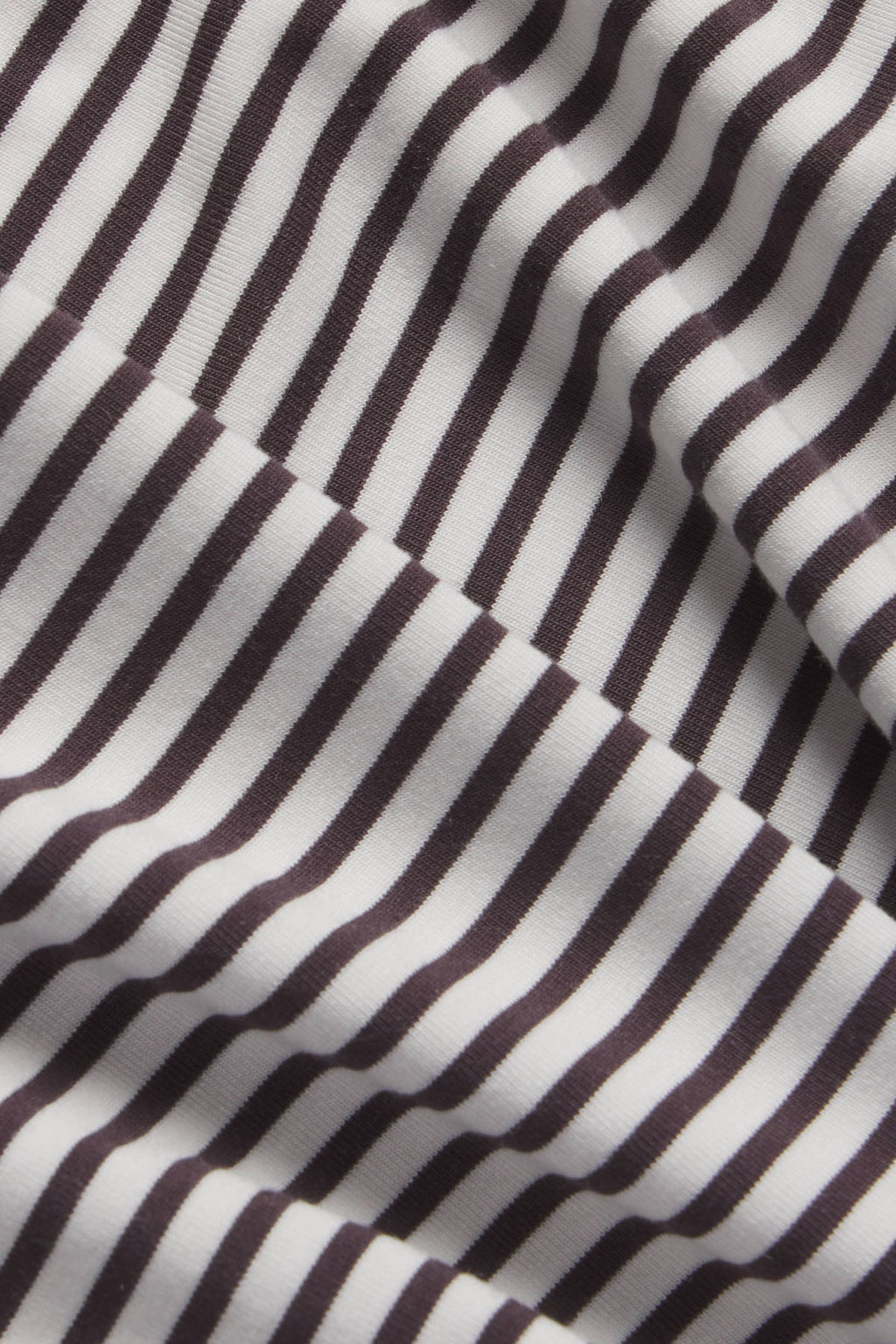 Brown and cream vertical striped fabric with textured weave and folded edges.