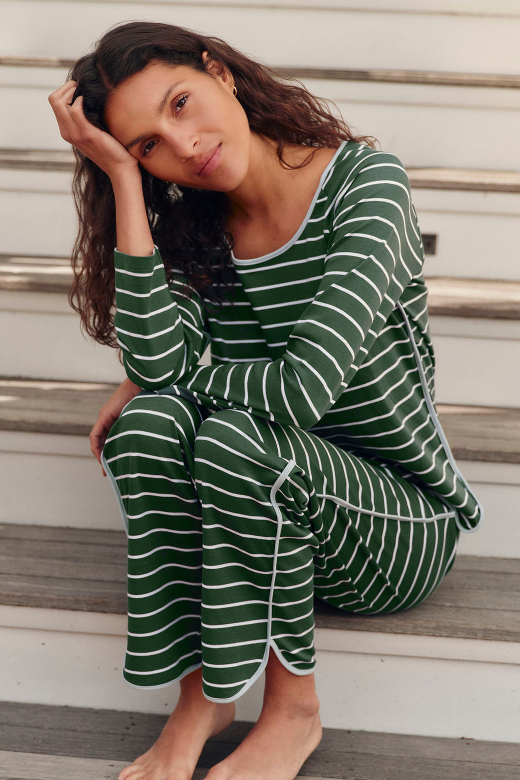 Woman wearing green and white striped long-sleeve shirt and matching cropped pants.
