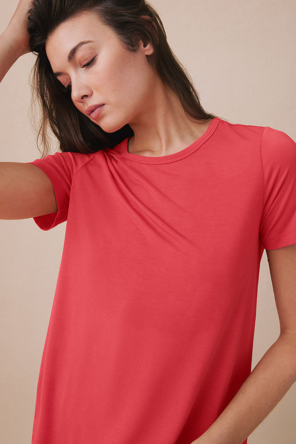 Woman wearing a cayenne red short-sleeved t-shirt with crew neckline.