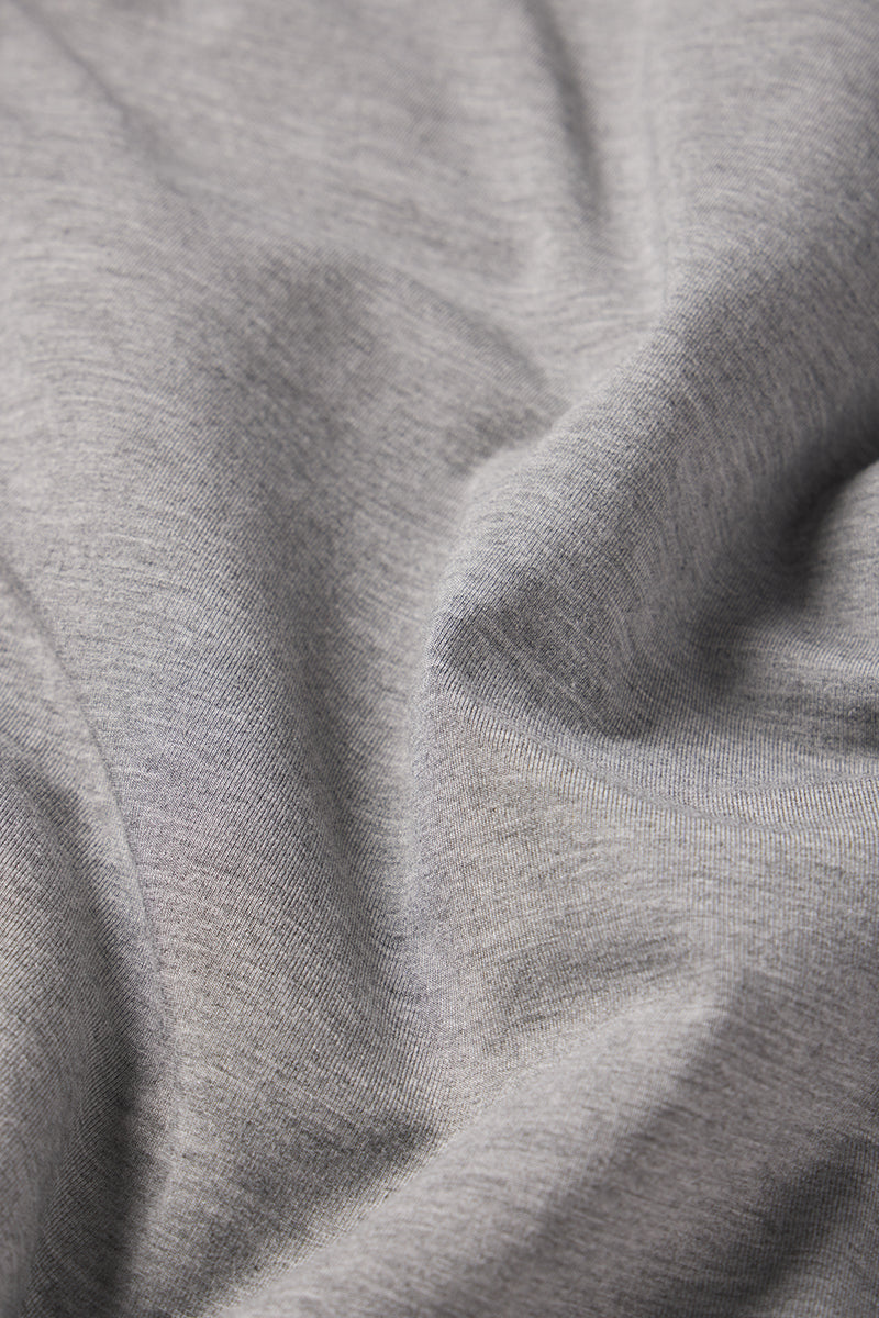 A close-up of the Mens Long Sleeve Bamboo Tee in Heather Gray, highlighting its soft bamboo fabric with gentle folds and a smooth texture.